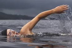 Foto de um homem respirando enquanto nada